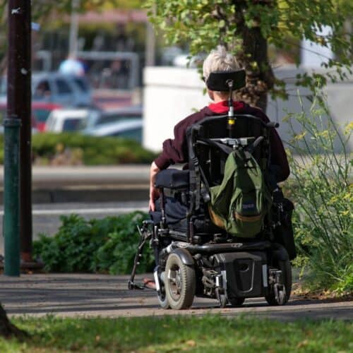 person with backpack in wheel chair