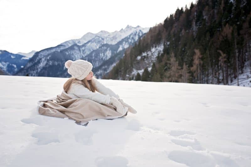 woman in the wild surrounded by snow