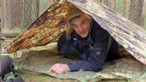 man under a tarp shelter