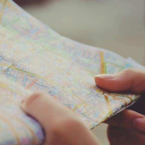 holding a paper map in hand