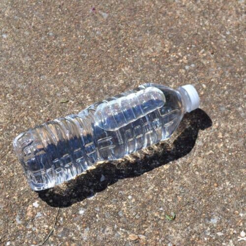 plastic water bottle with water in full sun