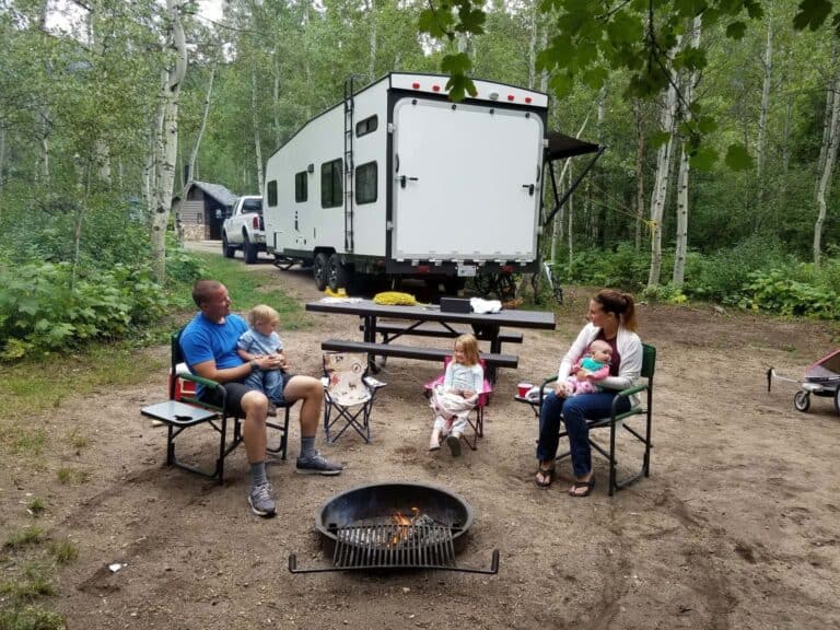 family camping in front of a trailer