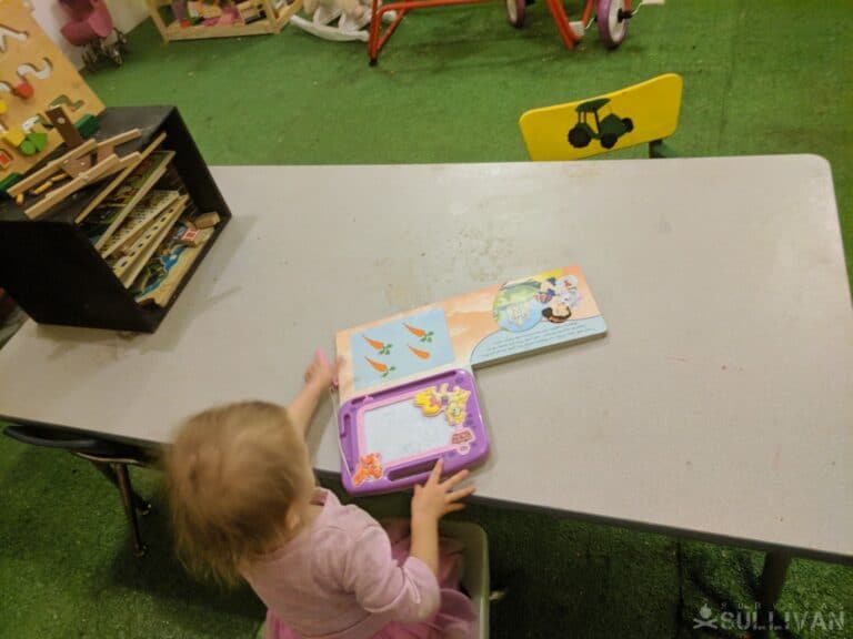 toddler sitting at homeschooling table