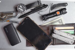 EDC kit: phone, wallet, cash, multi-tool, watch, tactical pen, folding knife