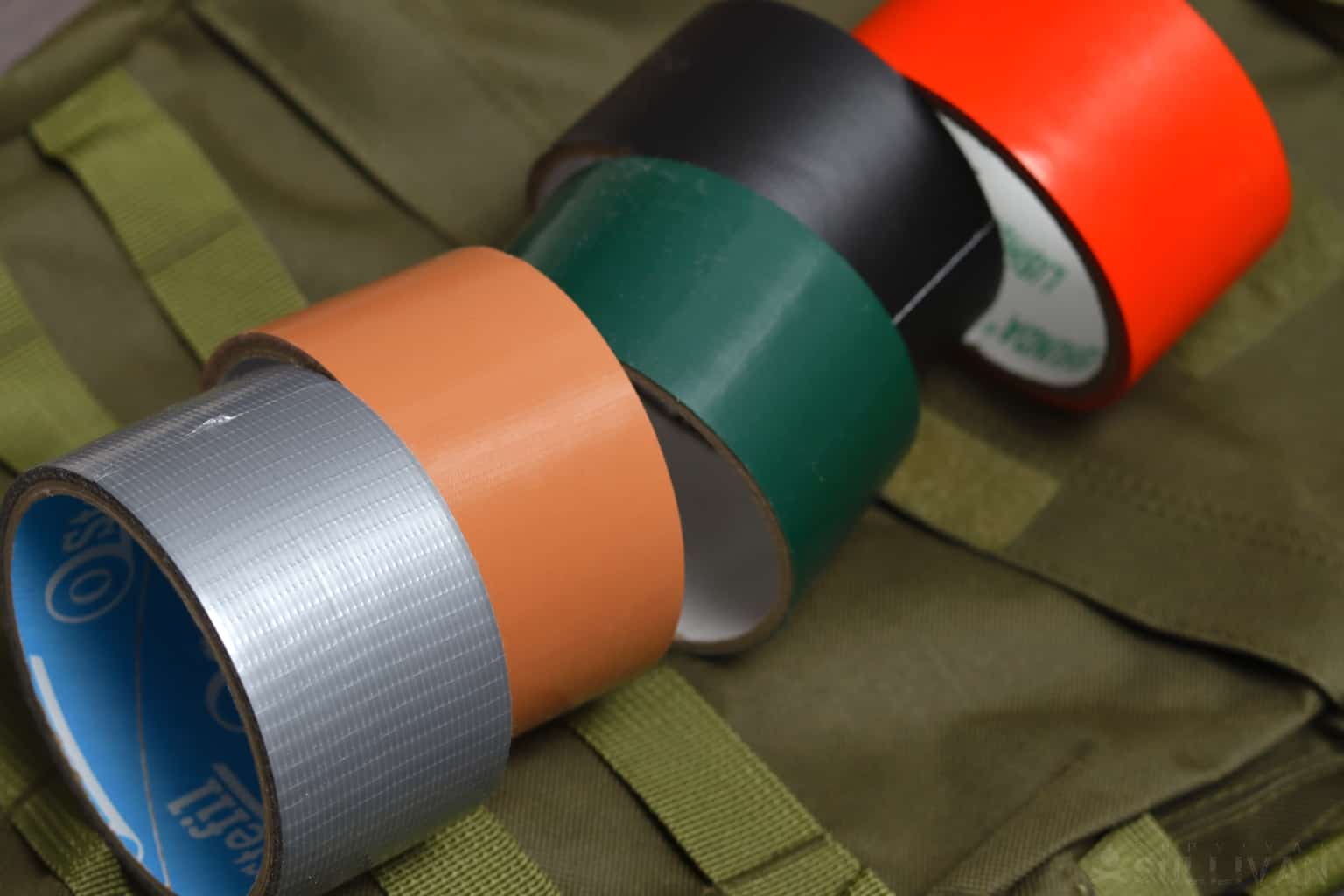 five rolls of colored duct tape: gray, brown, green, black, red