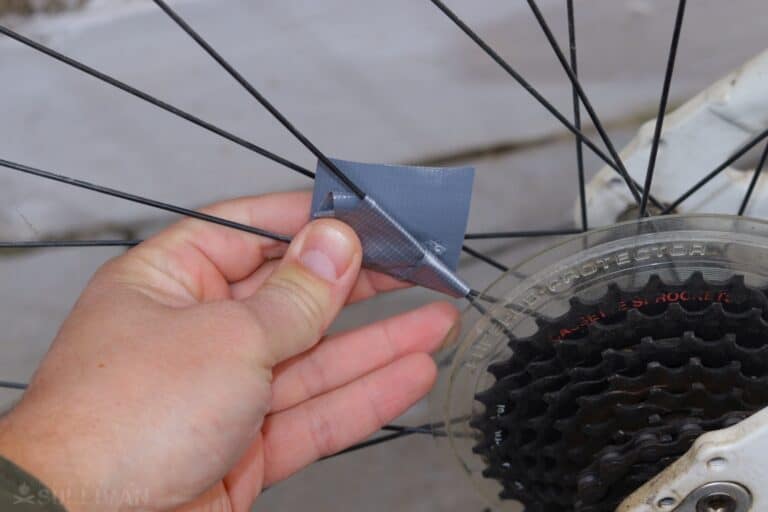 holding broken bike spoke together with duct tape