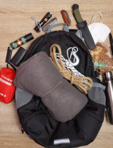 rope-lightweight-blanket, first aid kit, blanket, knives, and more over urban backpack