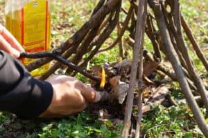 starting a fire with sticks and cooking oil
