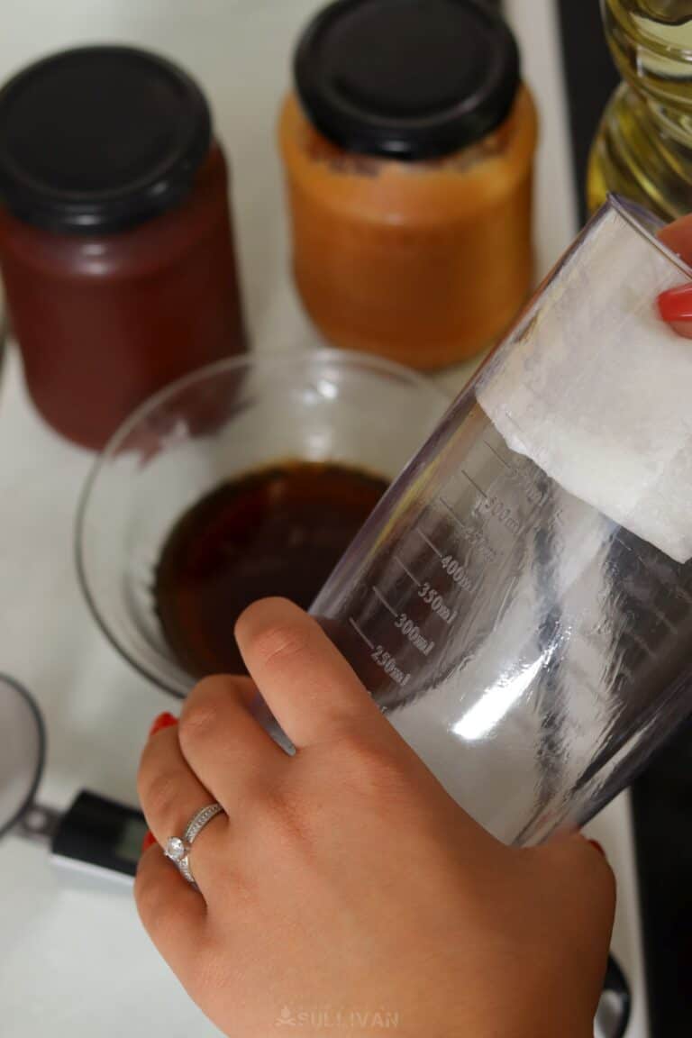 wiping measuring cup with cooking oil
