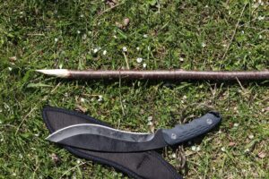 DIY spear from stick next to large knife