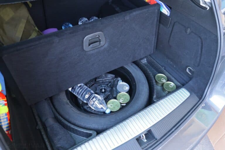 cans of food and water bottles inside car trunk