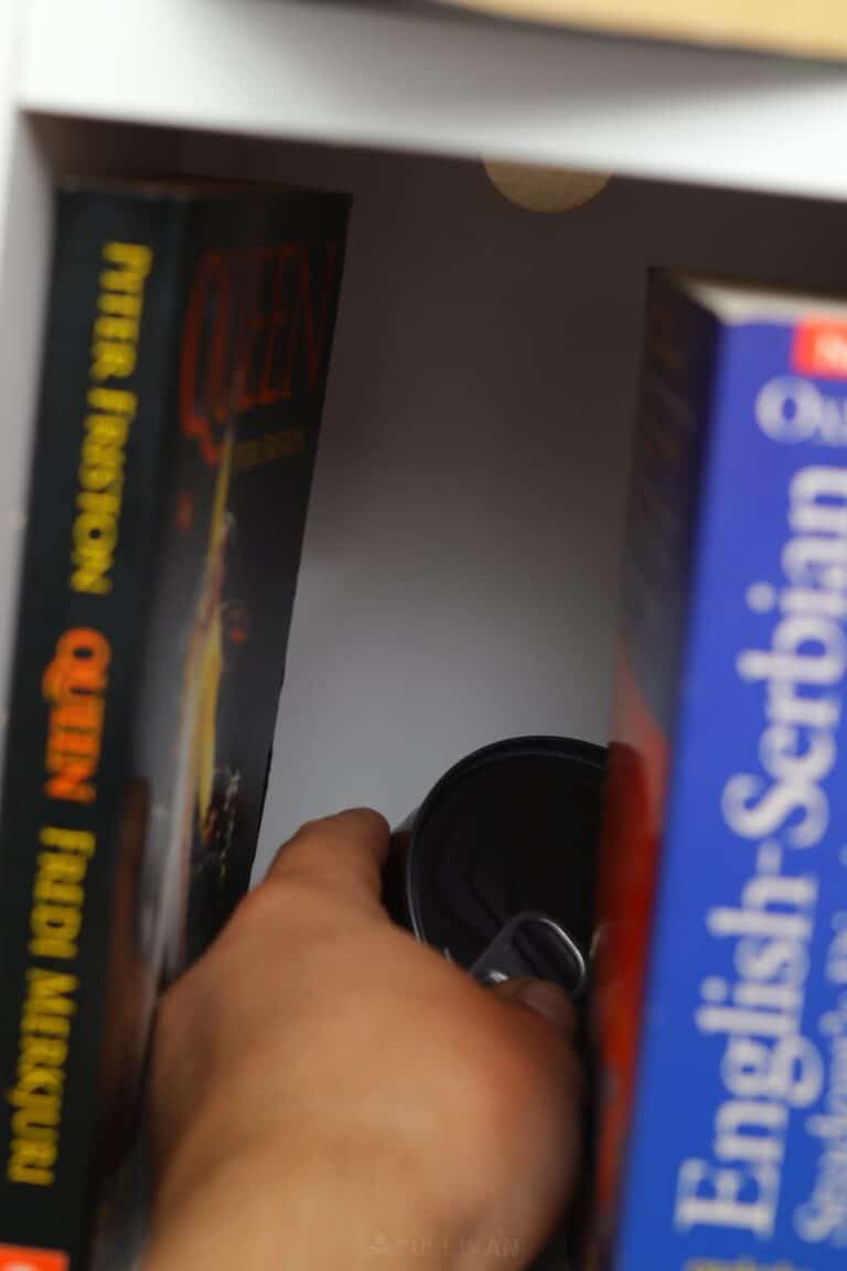 hiding a can of food behind books on bookshelf