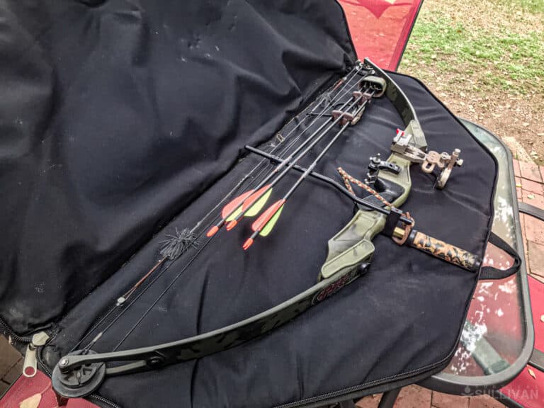 a compound bow with bag and arrows