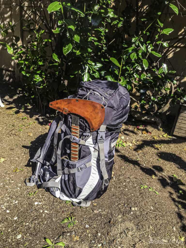 loaded hunting backpack with large hatchet attached to it