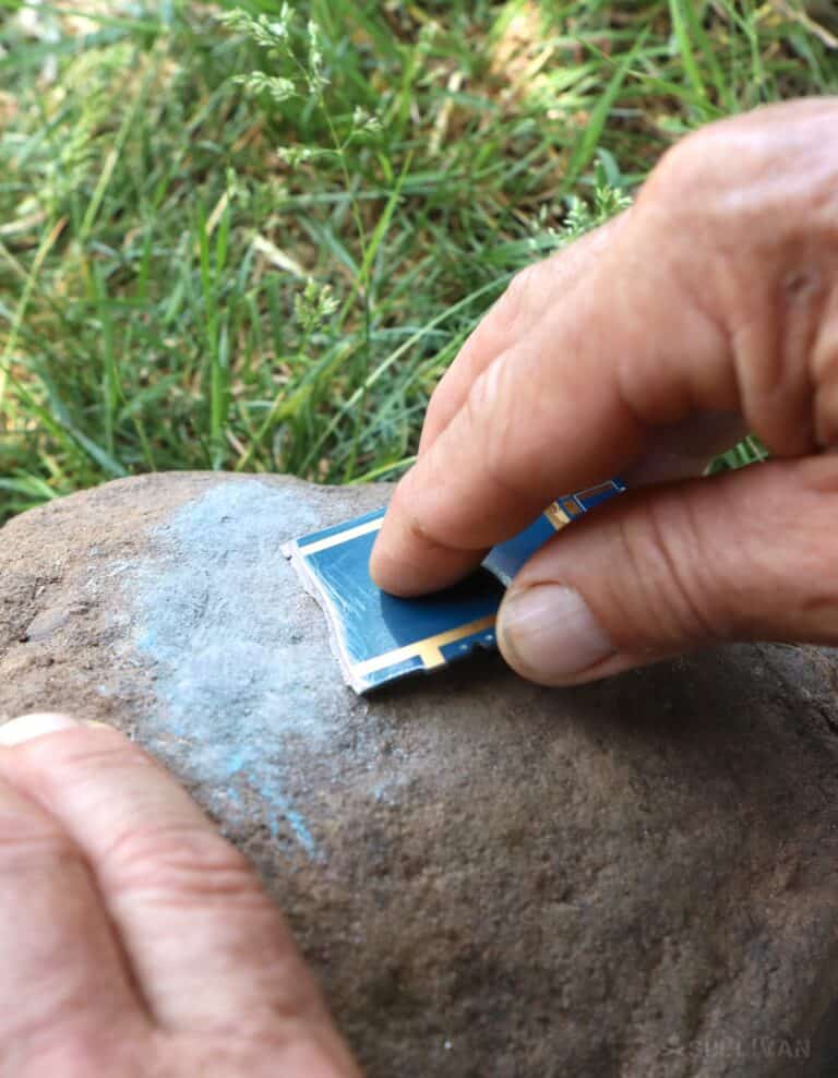 sharpening a smartphone circuit board on a rock