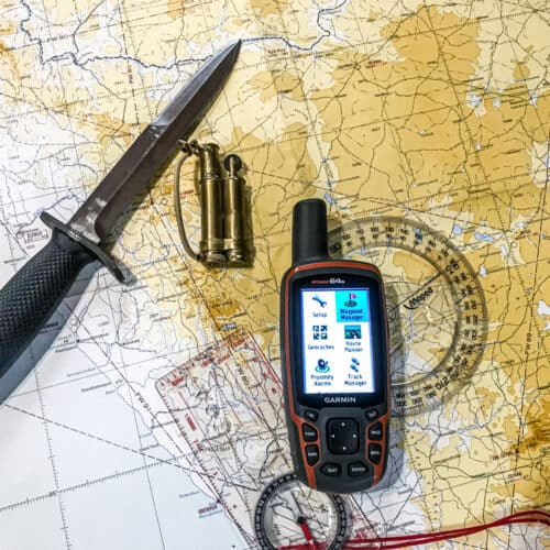 GPS, knife, map compass, and ruler over a topo map