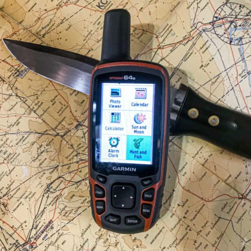 garmin GPS device over a map and a hunting knife