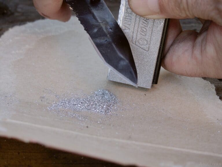 spine of the knife shaving magnesium shavings into a pile
