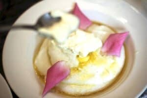 cornmeal mush with a dollop of cream and edible rose petals