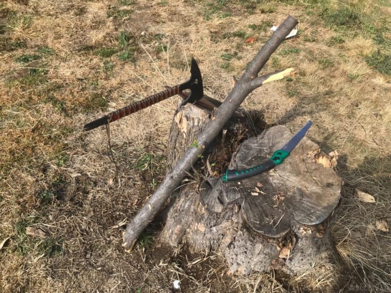 cut branch for bola weights next to folding saw and hatchet
