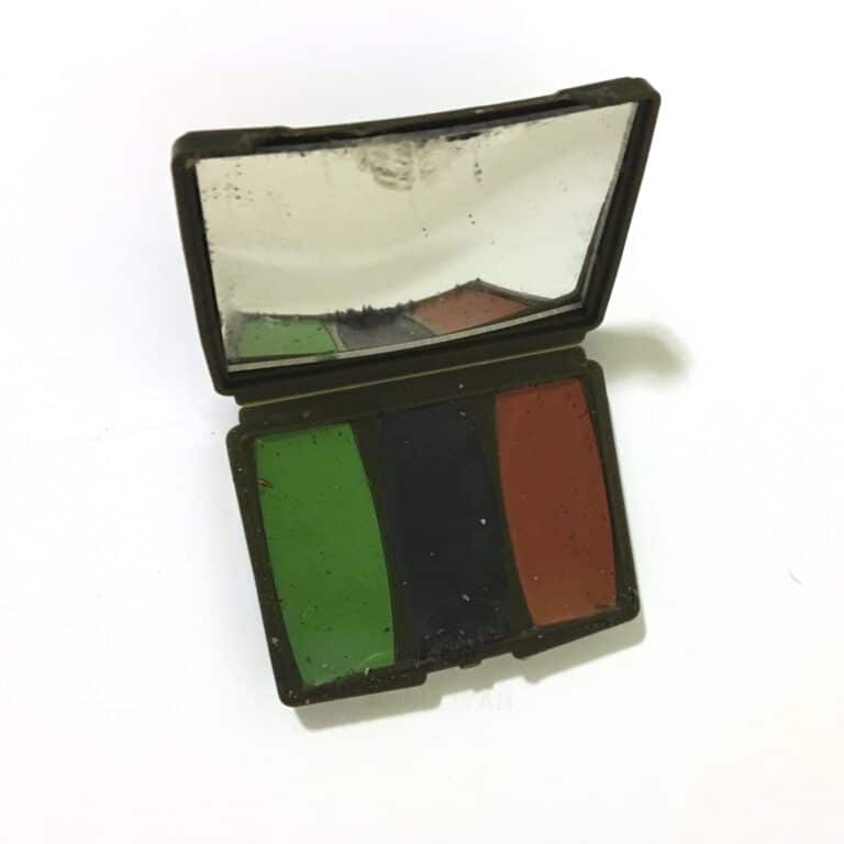 green and brown face paint with signaling mirror