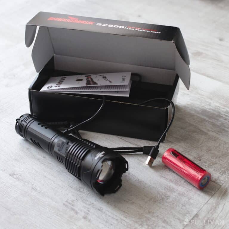 Shadowhawk S2800 flashlight next to its rechargeable battery