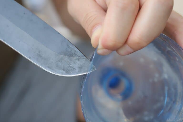 poking holes in plastic bottle with knife