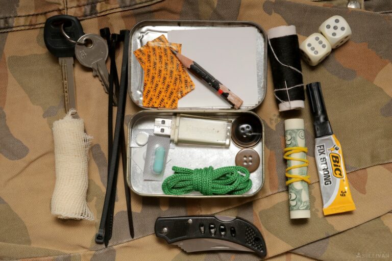 various EDC items in and around an Altoids tin