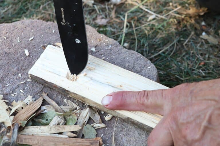 carving bow drill fireboard with knife