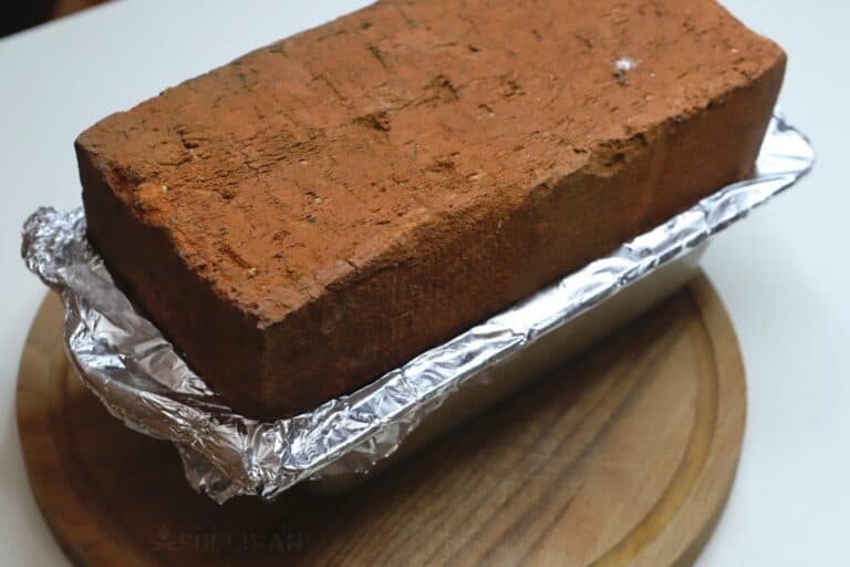 brick over loaf pan with spam inside