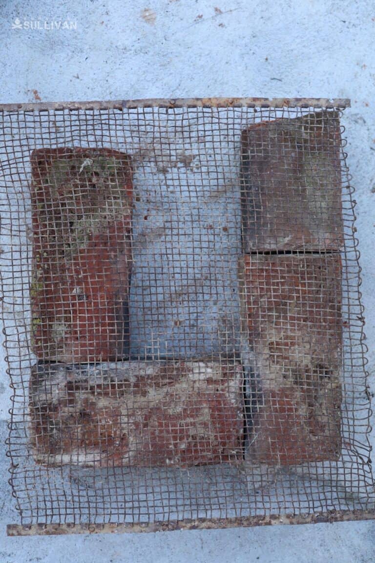 metal mesh over first layer of bricks