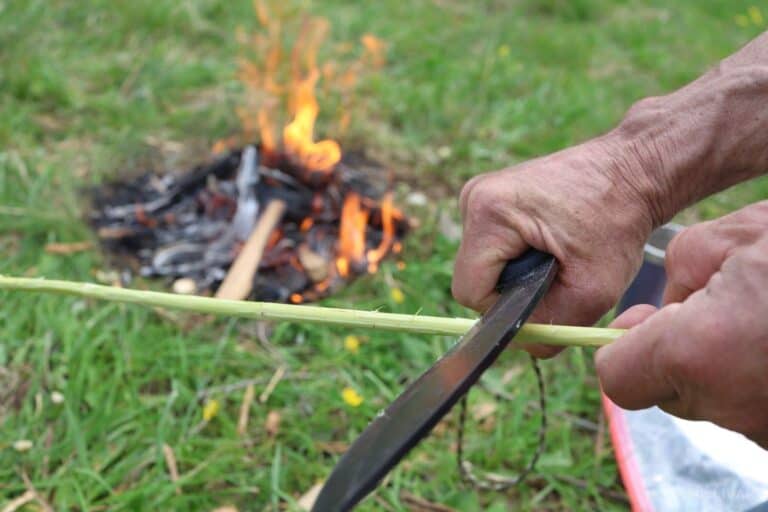 stripping stick of bark with knife